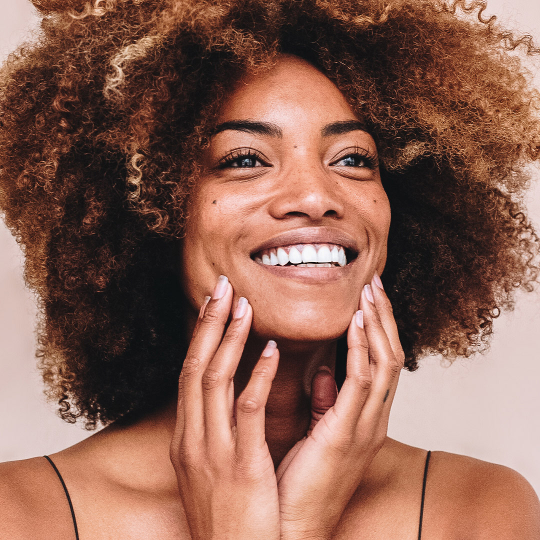 woman smiling wit natural hair, no makeup