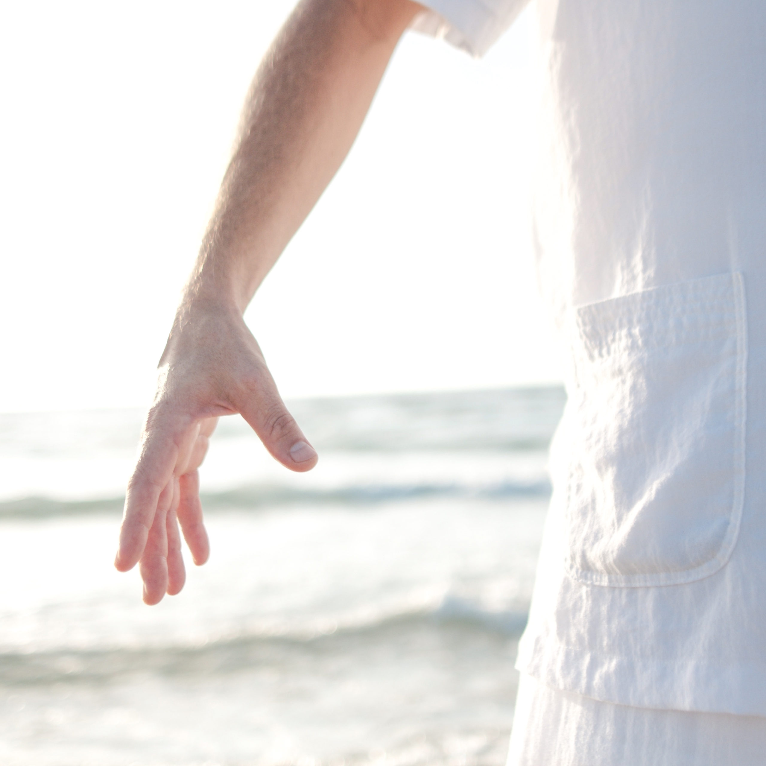 reaching hand, wearing white linen shirt